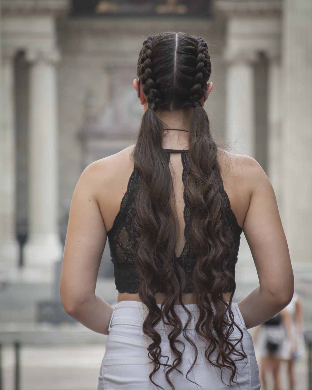 編み込みと毛先のウェーブを合わせたロングヘアの後ろ姿